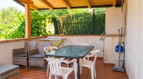 a patio with a glass table and chairs at Charming Apartment in Pisciotta with Terrace and Parking in Pisciotta