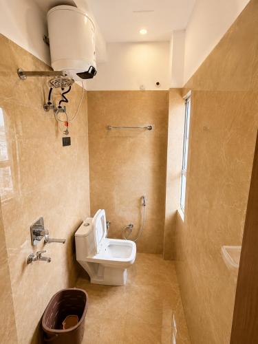 a bathroom with a toilet and a sink at Hotel Param INN in Gwalior