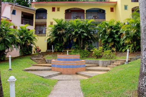 a yellow house with a cross in the yard at Studio charmant à Sainte-Anne avec piscine privée, 25 m² in Sainte-Anne