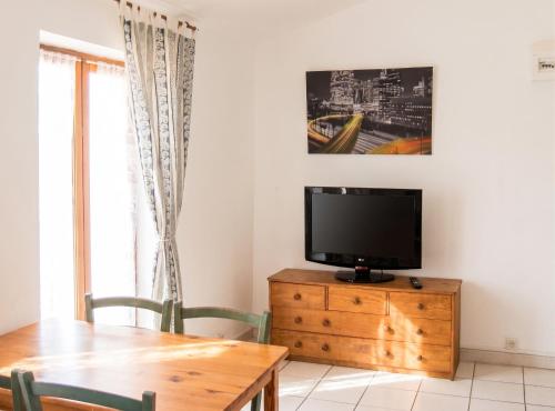 a dining room with a table and a tv on a dresser at Appartement avec vue sur mer à Port-Vendres, 60 m², balcons. in Port-Vendres
