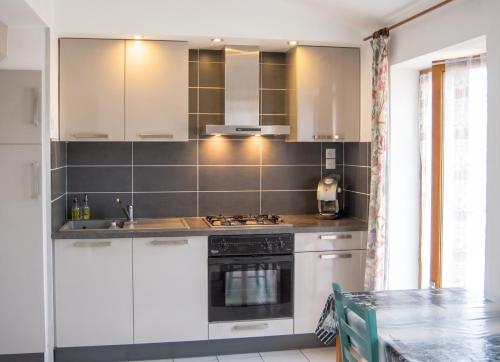 a kitchen with white cabinets and a stove at Appartement avec vue sur mer à Port-Vendres, 60 m², balcons. in Port-Vendres