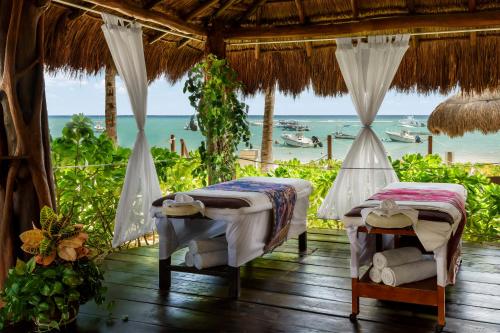 two beds in a room with a view of the ocean at The Reef Coco Beach Resort & Spa- Optional All Inclusive in Playa del Carmen