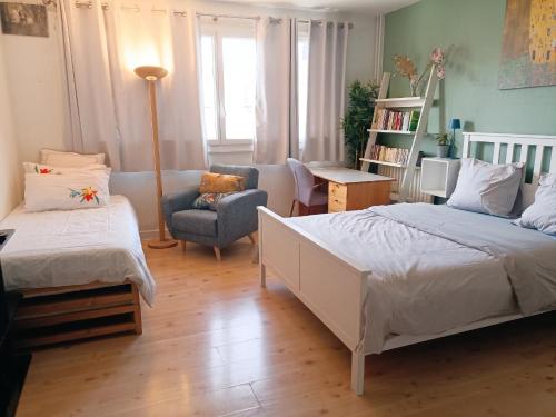 a bedroom with two beds and a couch and a chair at Studio accueillant au cœur de Paris - 30 m² - Tout inclus. in Paris