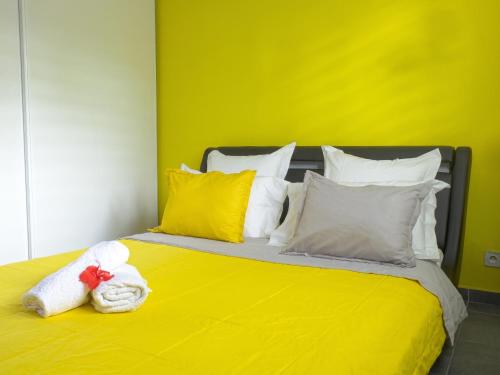 a yellow bed with a stuffed animal sitting on it at Appartement charmant à Lamentin avec piscine partagée in Lamentin