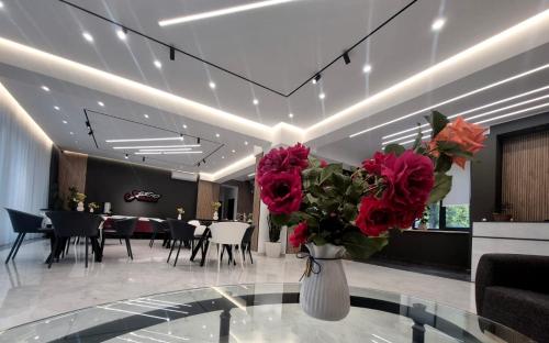 a dining room with a vase of red roses on a table at Musa Hotel in Yeghegis