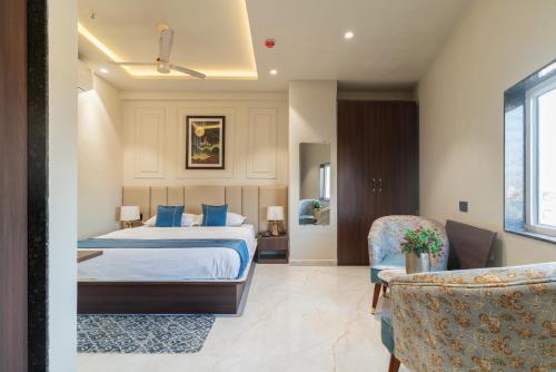 a bedroom with a bed with blue pillows at The Grand Dularia in Nagpur