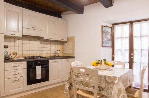 a kitchen with white cabinets and a table with a bowl of fruit at Modern Apartment near Arce City Centre, 62 m², Parking in Arce