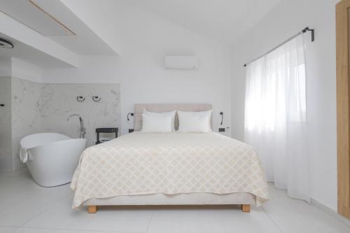 a white bedroom with a bed and a bath tub at Apartments ANA Karlobag in Karlobag