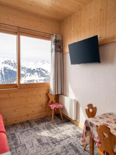 a room with a window and a tv on the wall at Studio chaleureux à Aime la Plagne 25 m² en montagne in Aime-La Plagne