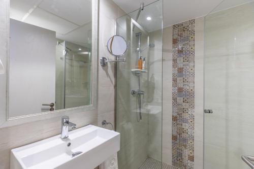 ein Badezimmer mit Waschbecken und Dusche mit Spiegel in der Unterkunft Hoposa Niu in Cala de Sant Vicent