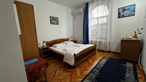 a bedroom with a bed and a large window at Vila Crinilor Căciulata in Căciulata