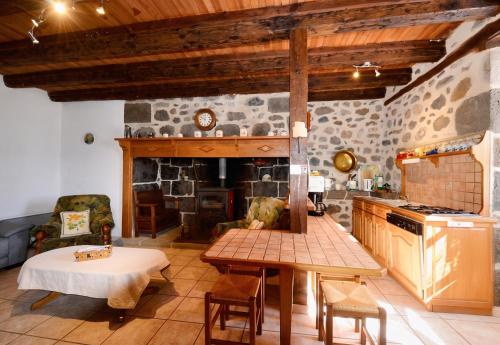 a kitchen with a table and a stone fireplace at Maison confortable avec vue sur la montagne à Le Fau in Le Fau