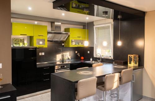 a kitchen with yellow cabinets and a black counter top at Appartement confortable à Apach avec balcon in Apach