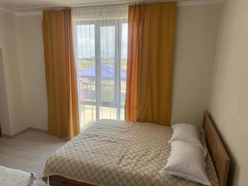 a bedroom with a bed and a large window at Аска in Imeni Kirova
