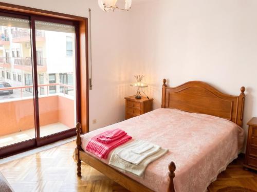 a bedroom with a bed and a large window at Spacious Apartment in Espinho with Fireplace, 87 sqm in Espinho