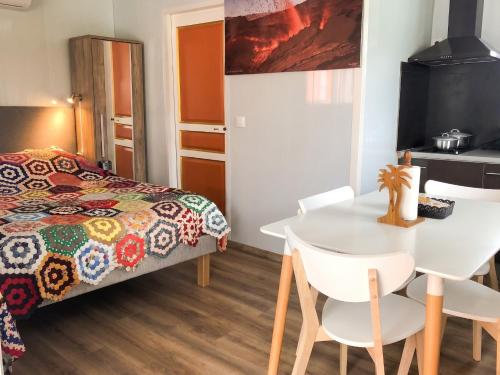 a bedroom with a bed and a table and chairs at Studio confortable à Sainte-Suzanne, 20 m², balcon in Sainte-Suzanne