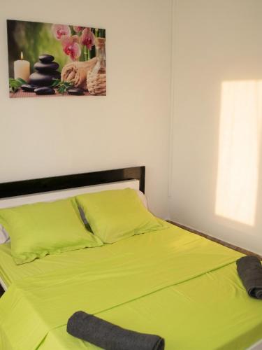 a bedroom with a yellow bed with a picture on the wall at Villa charmante à Le Tampon + Piscine in Le Tampon