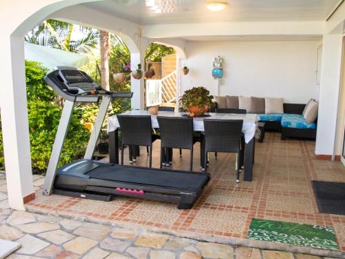a patio with a table and a treadmill at Villa charmante à Le Tampon + Piscine in Le Tampon