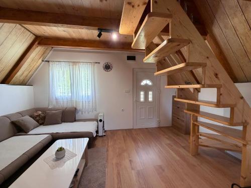 a living room with a couch and a spiral staircase at Soko Guest House in Žabljak