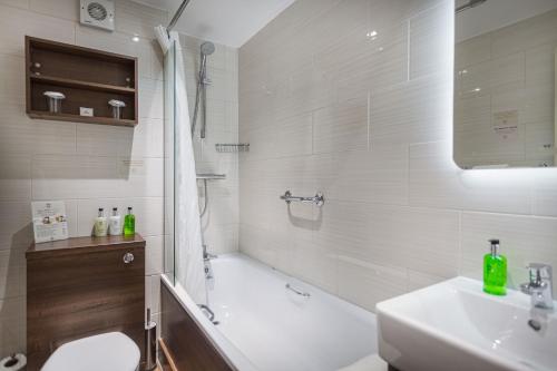 a bathroom with a tub and a toilet and a sink at The Royal Oak Hotel, Welshpool - The Coaching Inn Group in Welshpool