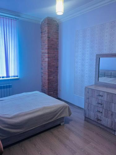 a bedroom with a bed and a brick wall at Yeganyan's Home in Ashtarak