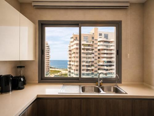 a kitchen with a sink and a window at Marina Premium Residences in Casablanca