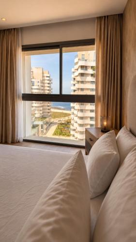 a bedroom with a bed and a large window at Marina Premium Residences in Casablanca