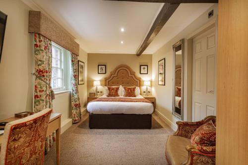 a bedroom with a large bed and a window at The Royal Oak Hotel, Welshpool - The Coaching Inn Group in Welshpool