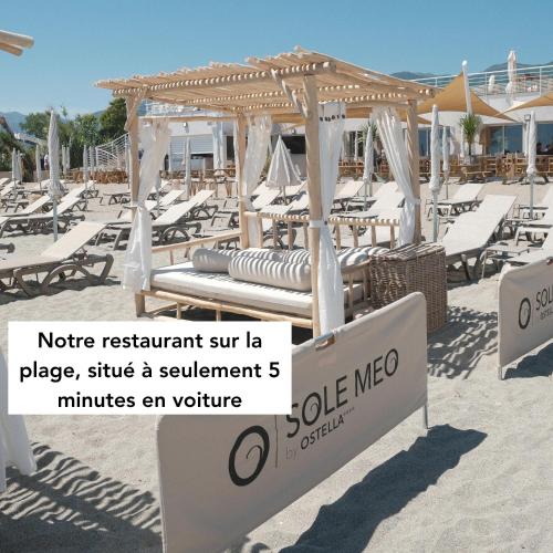 a beach with chairs and umbrellas on the sand at Ostella Spa & Resort in Bastia