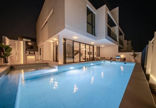 a large swimming pool in front of a house at Blausee Beachfront Villa with Private Pool in Al Ḩamrīyah