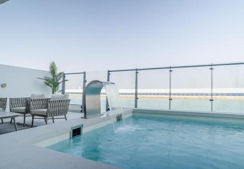 a swimming pool with a water fountain in a building at Blausee Beachfront Villa with Private Pool in Al Ḩamrīyah