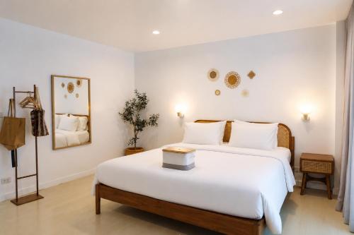 a bedroom with a large white bed and a table at Beachfront Pool Access Apartment FREE Disney Plus in Bangsaen