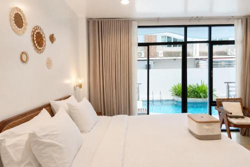 a bedroom with a white bed and a large window at Beachfront Pool Access Apartment FREE Disney Plus in Bangsaen