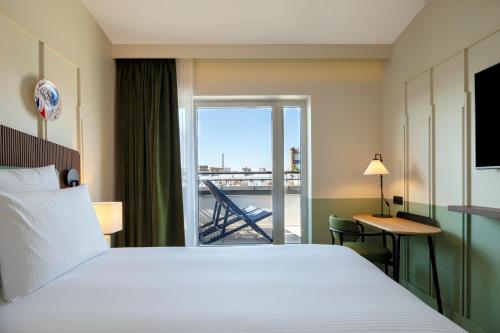 a hotel room with a bed and a balcony at Urban Hive Paris in Paris