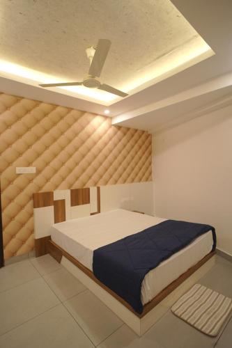 a bedroom with a bed and a ceiling fan at KPN Tower in Erāttupetta