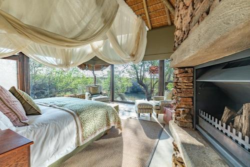 a bedroom with a bed and a fireplace at Last Word Makanyane in Laastepoort
