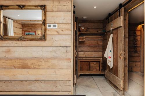 a bathroom with wooden walls and a mirror at Owl Barn in Little Milton