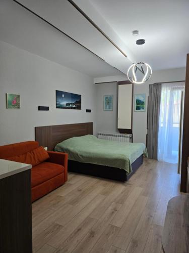 a bedroom with a bed and a couch at Cozy Ski-In Studio near forest at Crystal residence in Bakuriani