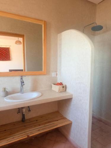 a bathroom with a sink and a mirror at Villa tawarda in Oumnas