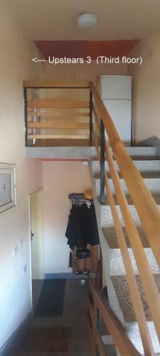 a staircase in a house with a coat hanging on the railing at 10Forward apt2 in Bitola