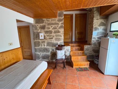 a room with a bed and a refrigerator and stairs at Cabana do Sil in Forcas