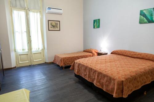 a hotel room with two beds and a window at Hotel Reina in Buenos Aires
