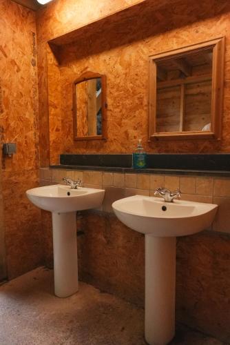 two sinks in a bathroom with two windows at Devon Belltents - Beesands in Kingsbridge