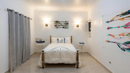 a bedroom with a bed in a white room at Los Patos Waterfront Private Suites in Los Patos
