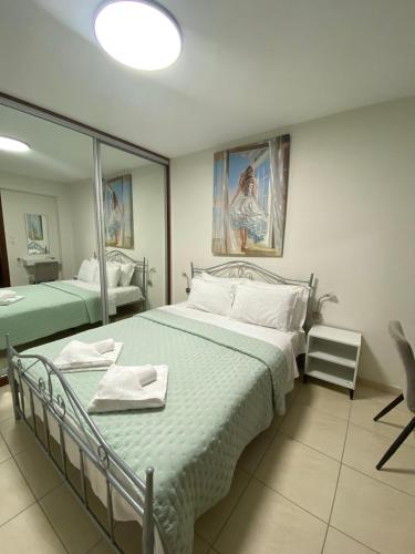 a bedroom with two beds and a mirror at A & G Apartment in Nea Peramos
