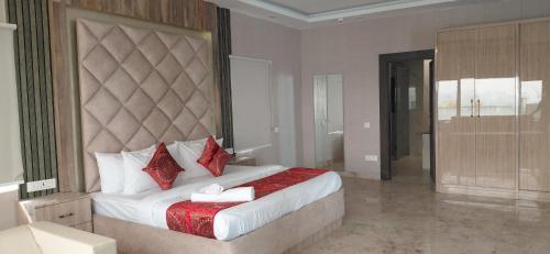 a bedroom with a large bed with red pillows at Landmark Resort in Sonīpat