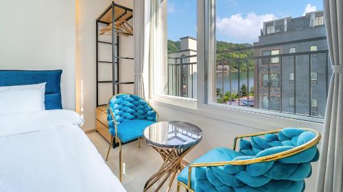 a bedroom with a bed and two chairs and a window at Gapyeong Boreum-Dal Poolvilla in Gapyeong