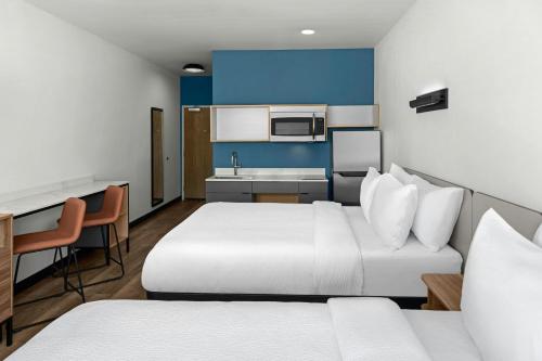 a hotel room with two beds and a kitchen at StudioRes by Marriott Greensboro Airport in Greensboro