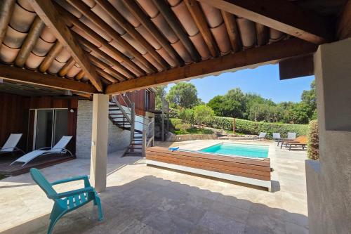a patio with a swimming pool and a wooden pergola at CASA FUNTA - villa T5 - vue mer- piscine in Sainte-Lucie de Porto-Vecchio