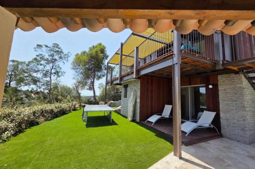 a patio with a table and chairs on a lawn at CASA FUNTA - villa T5 - vue mer- piscine in Sainte-Lucie de Porto-Vecchio
